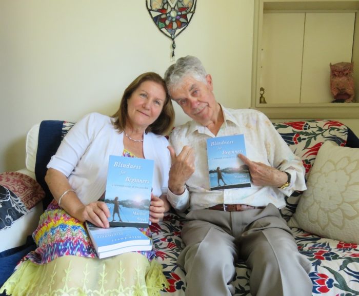 Maribel and her father sitting together, her father proudly holding up a copy of her book