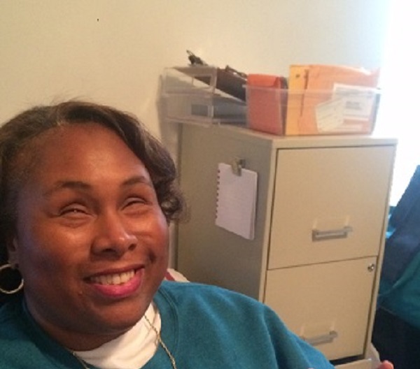 Empish in her home office, smiling. File cabinet in the background