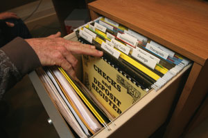 File drawer with large print labels and hand of person going through the drawer