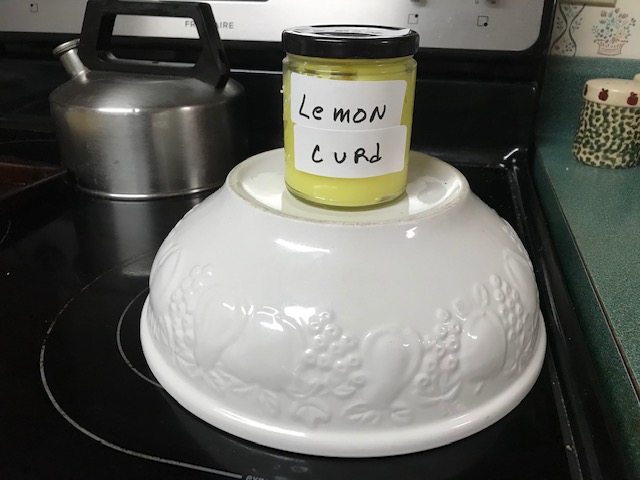 Jar of lemon curd displayed on stove top