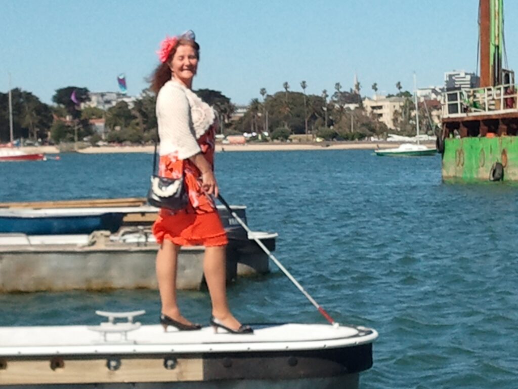Maribel Standing on Pier with white cane in front of her (Photo by Harry Williamson)