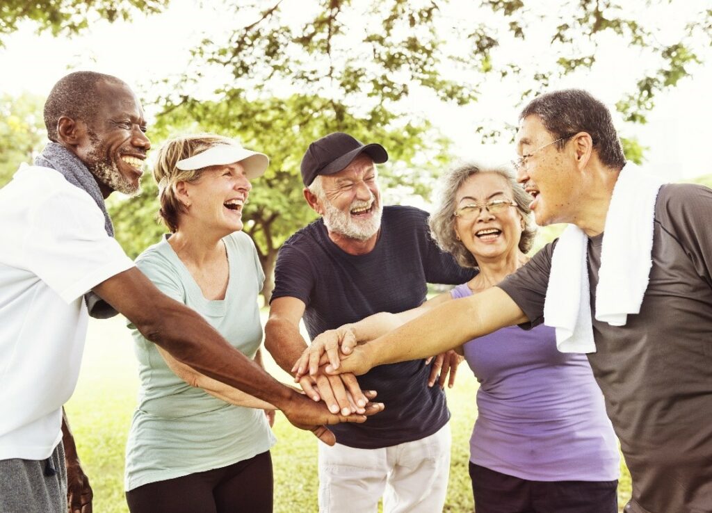 group of diverse individuals holding hands and smiling
