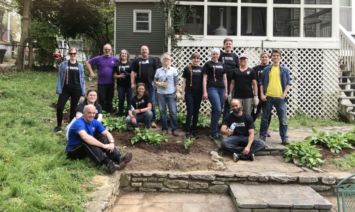 volunteers planting garden in front of house