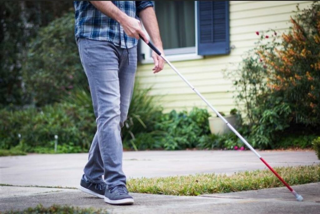 man walking with white cane