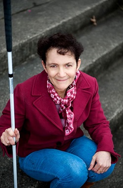 woman squatting using white cane