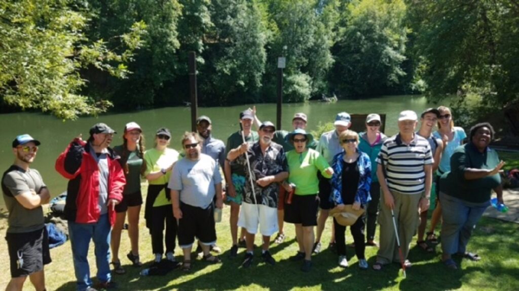 Group of People Standing in Front of Lake, Some Holding White Canes Photo used with permission from Hull Park for the Blind