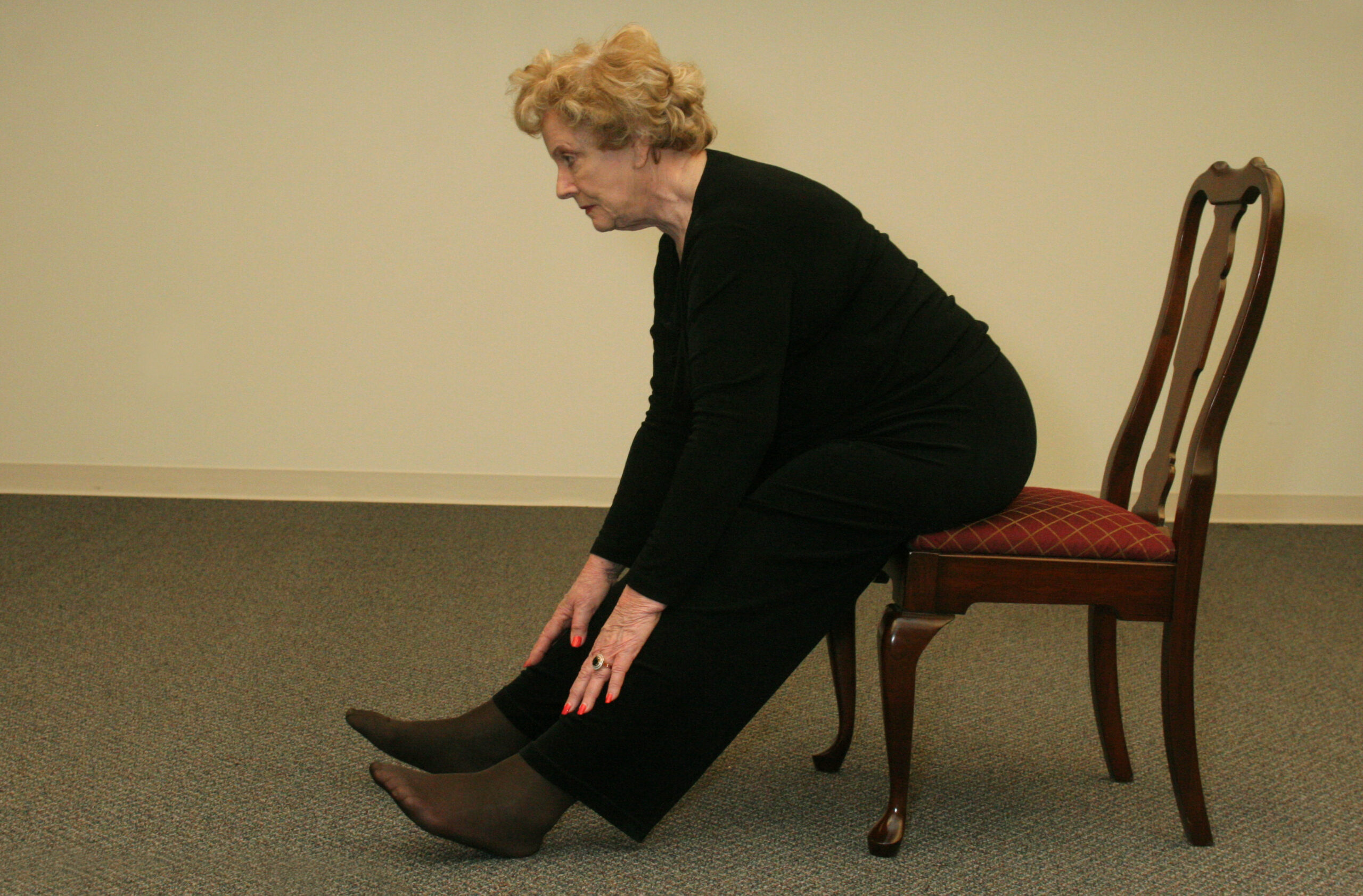 Older Woman Sitting on Chair Stretching
